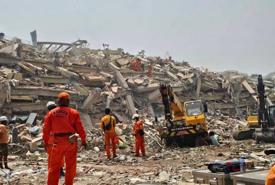 Rescue teams conduct search and rescue operations amid the debris of the Sky Villa condominium building that collapsed during the earthquake.