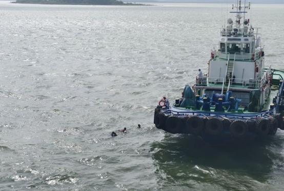 Caption: Local villagers who fell in the water were seen being rescued after their boat capsized near Maday Island