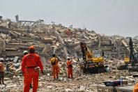 Rescue teams conduct search and rescue operations amid the debris of the Sky Villa condominium building that collapsed during the earthquake.