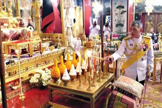 His Majesty King Maha Vajiralongkorn yesterday lights candles at the Baisal Daksin Throne Hall to consecrate the ceremonial objects which will be used in the coronation ceremony.