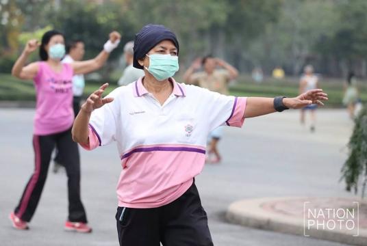 Many people wear masks as they attend aerobic workouts at Lumpini Park in central Bangkok yesterday. The PM2.5 level has been dangerously high, covering the capital with thick smog. PhotoAnant Chantarasoot