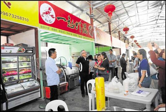 Trade Secretary Ramon Lopez (center) talks to stall owners at China Food City to check their compliance with business regulations. —photo courtesy of DTI