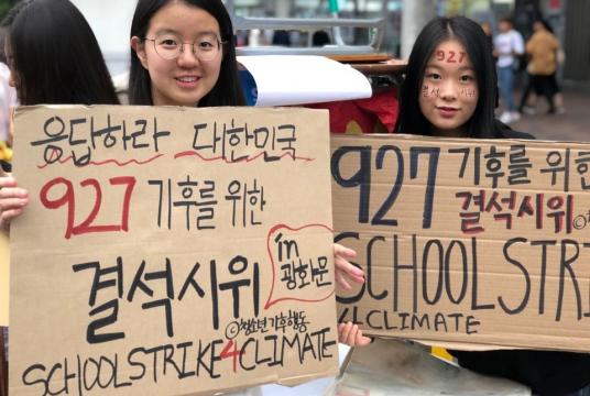 Kim Do-hyeon, a 15-year-old student, holds a placard reading "Answer, Korea. School strike for climate on Sept. 27" with a fellow campaigner. (Ock Hyun-ju/The Korea Herald)