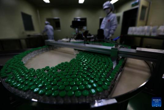Staff members work on a production line of Covid-19 vaccines at Myanmar Pharmaceutical Industry in Yangon, Myanmar on March 23, 2022. - Xinhua