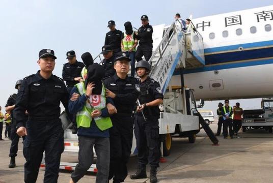 In this file photo dated Nov 7, 2018, the police escort suspects of telecom fraud to get off a plane at Shenzhen Bao'an International Airport in Shenzhen, south China's Guangdong province. (PHOTO / XINHUA)