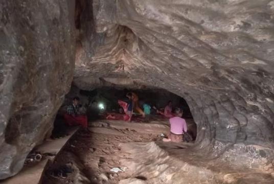 Caption: People seen sheltering at a cave in Kyaikmaraw Township