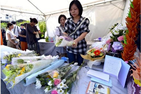 People offer flowers for victims of the Kyoto Animation arson attack on Sunday in Fushimi Ward, Kyoto.