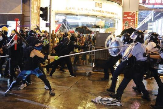Radical protesters attack police officers with metal rods at an unauthorized assembly in Hong Kong on Sunday. (PHOTO/ CHINA DAILY)
