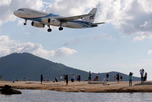 A passenger plane flies over the Haad Mai Khao Beach in Phuket. /The Nation filephoto