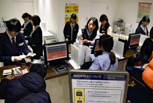 Chinese tourists and other people go through tax-exemption procedures at a counter in the Shinjuku store of Odakyu Department Store Co. in Tokyo on Friday. 