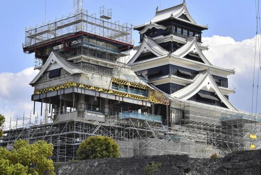 Kumamoto Castle’s Dai-Tenshu tower, right, which had its exterior restored, and Sho-Tenshu tower, which still requires construction work on its stone wall, are seen Friday in Chuo Ward, Kumamoto. /The Yomiuri Shimbun 