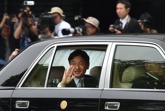 Japan's new Emperor Naruhito (C) waves to well-wishers as he arrives back at the Imperial Palace in Tokyo on May 1, 2019. - Japan's new Emperor Naruhito formally ascended the Chrysanthemum Throne on May 1, a day after his father abdicated from the world's oldest monarchy and ushered in a new imperial era. (Photo by Kazuhiro NOGI / AFP)
