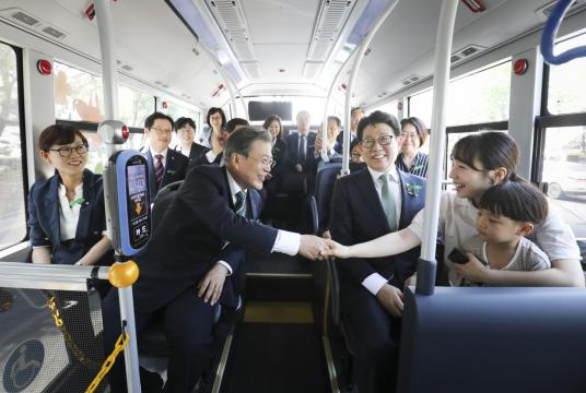 President Moon Jae-in shakes hands with one of passengers participating in a test drive of the nation‘s first hydrogen-fueled intracity bus in Changwon, some 300 kilometers south of Seoul, on Wednesday. (Yonhap)