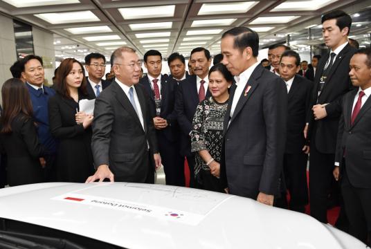 President of Indonesia Joko Widodo (center right) and Executive Vice Chairman of Hyundai Motor Group Chung Euisun (center left) chat in front of Kona Electric after leaving a signature on the car, prior to the investment clinch ceremony which took place at the automaker’s plant in Ulsan, Tuesday. (Hyundai Motor Group)