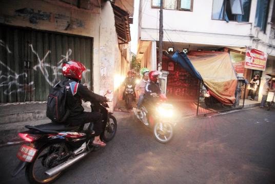 Tight space: Motorcyclists ride through a narrow alley in Kemanggisan, Palmerah, West Jakarta. (The Jakarta Post/Dhoni Setiawan)