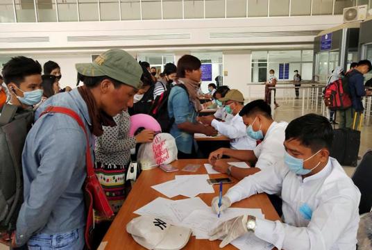 Migrant workers from Myanmar fill out information at the Myawaddy border office after passing through border gate at Myawaddy, Myanmar, after leaving Thailand due to the coronavirus disease (COVID-19) outbreak, in this image obtained via social media. (REUTERS/THANT ZIN AUNG)