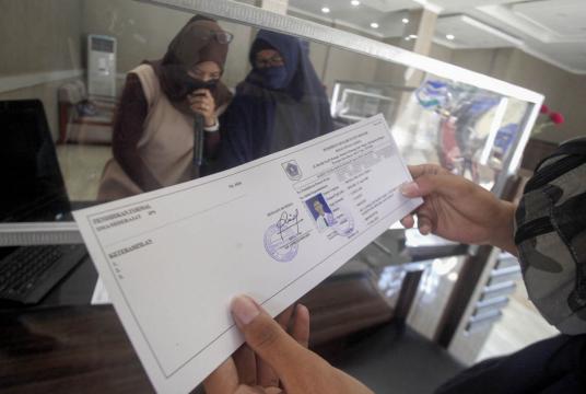 A job seeker obtains an AK/1 card, also known as a yellow card, designated for unemployed citizens, at the Bogor regency Manpower Agency in Cibinong, Bogor, West Java, on June 12. (Antara/Yulius Satria Wijaya) 