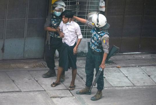 Gotcha: Riot police officers detain a demonstrator during a protest against the military coup in Yangon, Myanmar, on March 19. (Reuters/Stringer)