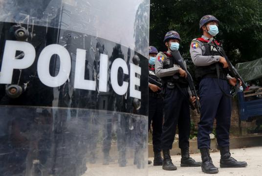 Police personnel stand guard during a demonstration by supporters of detained Buddhist monk Ashin Wirathu in front of a court house in Yangon on November 3, 2020. Wirathu, a hardline Buddhist monk turned himself in November 2, after 18 months on the run -- and less than a week before Myanmar's national elections -- a move analysts described as a bid to (AFP/Sai Aung Main)