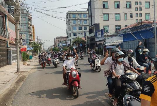 This photo taken and received courtesy of an anonymous source via Facebook on April 15, 2021 shows protesters on scooters holding up the three finger salute during a demonstration against the military coup in Mandalay. (AFP/Handout)