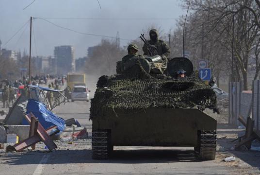 Pro-Russian troops in uniforms without insignia drive an armoured vehicle in Mariupol, on March 19, 2022. PHOTO: REUTERS