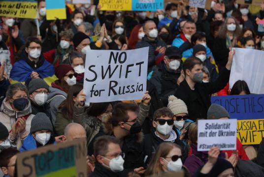 A protester holds a placard reading "No SWIFT for Russia" during a rally against Russia's invasion of Ukraine on Saturday in Frankfurt am Main, western Germany. (AFP-Yonhap)
