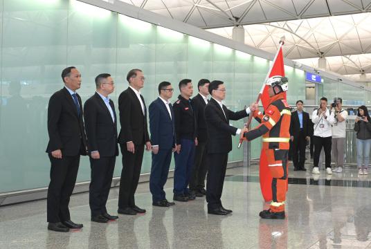 Hong Kong Chief Executive John Lee Ka-chiu (second right), presents the flag to the representative of the special administrative region's search and rescue team which left the city to assist in the search and rescue work at the earthquake-stricken areas in Myanmar, on March 29, 2025. (PHOTO / HKSAR GOVERNMENT)