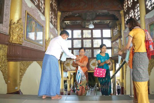 People distribute face masks to pilgrims in Shwedagon Pagoda (Photo-Kyi Naing)