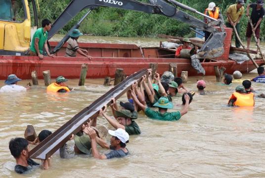 Local police officers and residents in the Central Highlands province of Đắk Lắk use an iron pile to fix a section of the Quảng Điền dyke system that broke yesterday due to prolonged heavy rain. VNA/VNS Photo Tuấn Anh