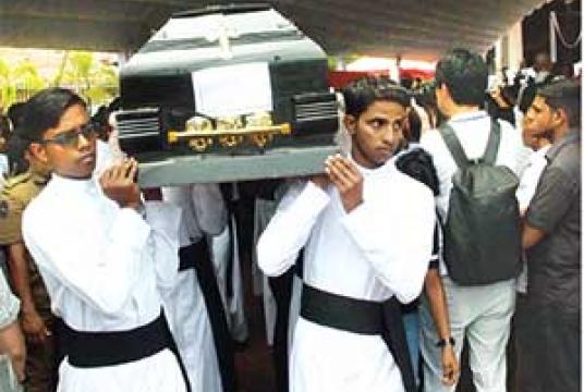 Funerals of the victims of the Easter Sunday carnage were held in and around Katuwapitiya area yesterday. Catholic priests carry the coffin of a victim to a cemetery in the Katunayake area (Pic by Ananda Nissanka)