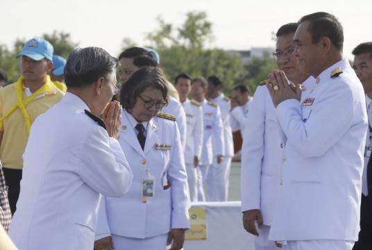 Prime Minister Prayut Chanocha greets House Speaker Chuan Leekpai at Sanam Luang yesterday when they joined others in offering alms to 410 Buddhist monks as part of merit-making to mark Her Majesty the Queen’s birthday. BY Prasert Thepsri/The Nation