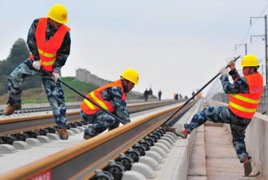 In this undated photo, workers from China Railway Construction Group lay tracks along the Chengdu-Guiyang high-speed railway line. (CAO NING / FOR CHINA DAILY)