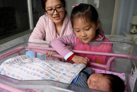 In this Dec 2, 2018 photo, a mother and her daughter watch over the family's newborn baby at an infant healthcare center in Hefei, Anhui province. (PHOTO / XINHUA)