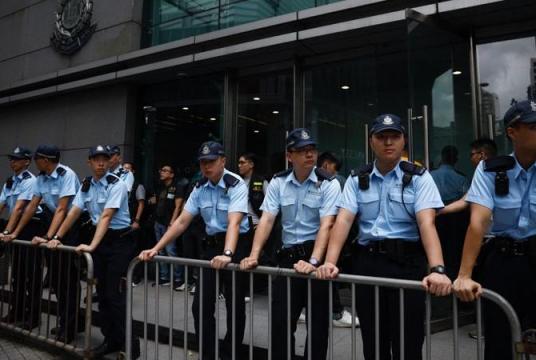 Police officers stand guard outside the police headquarters in Wan Chai on June 21, 2019. (ROY LIU / CHINA DAILY)