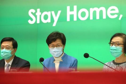 Chief Executive Carrie Lam Cheng Yuet-ngor (center) on Friday announces measures to limit social interactions as part of the government’s efforts to contain the resurgence of coronavirus infections. (PARKER ZHENG / CHINA DAILY)