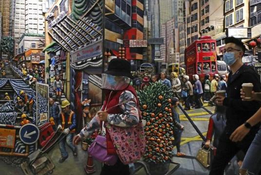 People wearing face masks to protect themselves from possibly contracting the coronavirus walk past a painting in Hong Kong, April 25, 2020. (KIN CHEUNG / AP)