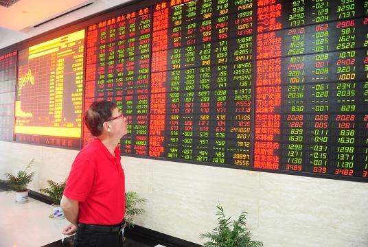 An investor looks at share prices at a brokerage in Fuyang, Anhui province, on Friday. [Photo by Wang Biao / For China Daily]