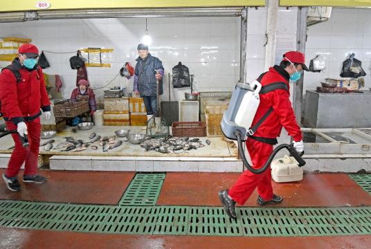 Workers disinfect a market in Wuhan, Hubei province, on Sunday. MIAO JIAN/CHANGJIANG DAILY