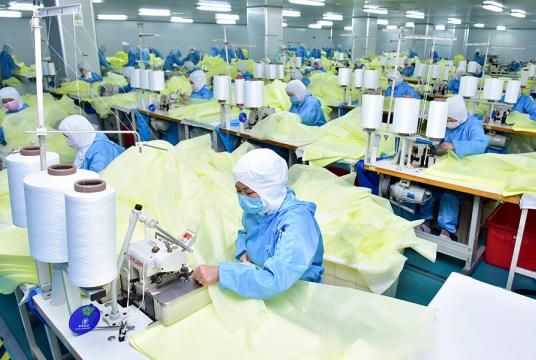 Factory employees work extra hours to make isolation gowns at a factory in Xinle, Hebei province, on Friday. [Photo/for China Daily]