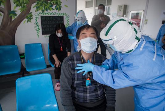 A medical worker teaches a patient who contracted the novel coronavirus pneumonia to do acupressure massage to help him recover at the Wuhan pulmonary hospital in Wuhan, Hubei province, March 19, 2020. [Photo/Xinhua] 