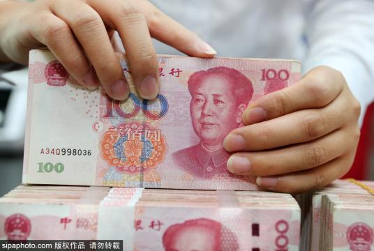 A clerk counts cash at a bank in Natong, South China's Jiangsu province. [Photo/Sipa] 