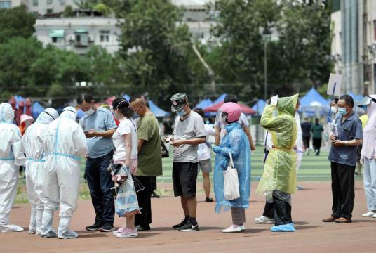 Residents undergo nucleic acid tests for COVID-19 on Monday night at a stadium in Beijing's Xicheng district. [Photo by Zou Hong/China Daily] 