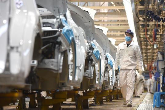 An employee conducts checks on Dongfeng Honda cars at the company's assembly line in Wuhan, capital of Hubei province. [Photo by Zhou Chao/For China Daily]