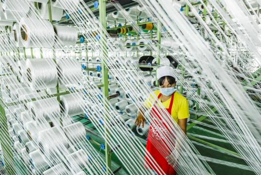 A woman works at a chemical fiber company in Zunhua, Hebei province, on Thursday. China's GDP grew by 3.2 percent year-on-year in the second quarter, compared with a 6.8 percent decline in the first quarter. LIU MANCANG/ XINHUA 