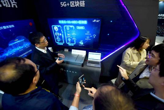 Visitors learn about the future applications of the combination of 5G and blockchain technology at a recent industrial expo in Hangzhou, Zhejiang province. [Photo by Long Wei/For China Daily]