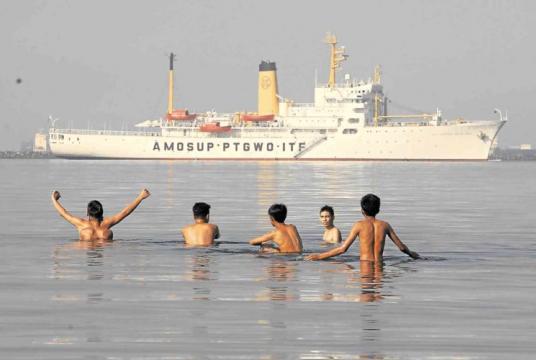 A group of men go swimming in Manila Bay despite the health department’s warning that bathing in its water can lead to gastrointestinal and skin diseases. —MARIANNE BERMUDEZ