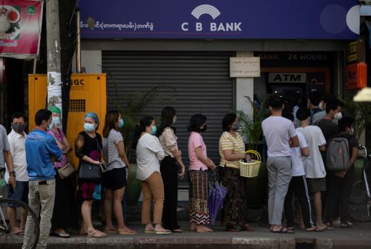 People line up outside a bank branch in Yangon, Myanmar, on Monday. Local banks temporarily suspended service for a number of hours on Monday due to poor internet connections, the Myanmar Banks Association said. [Photo/Agencies] 