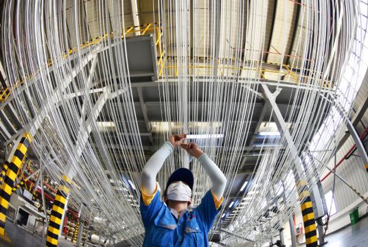 A worker checks the operation of a carbon fiber production line at a factory in Lianyungang, Jiangsu province. [Photo by Geng Yuhe/For China Daily]