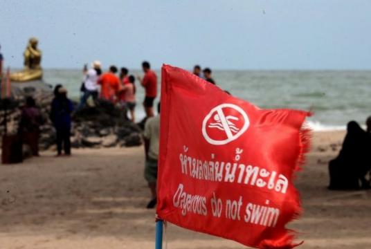 Authorities raise a red flag to ban swimming at a beach in Songkhla province of Thailand on Wednesday./The Nation