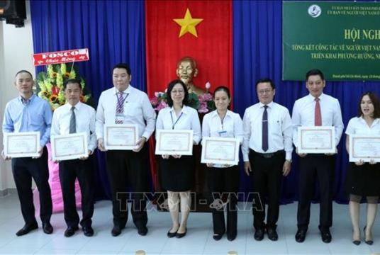 Võ Thành Chất (third from left), vice chairman of the HCM City Overseas Vietnamese Committee, presents Certificates of Merit to individuals who have had significant achievements in their work in 2019. VNA/VNS Photo Xuân Khu